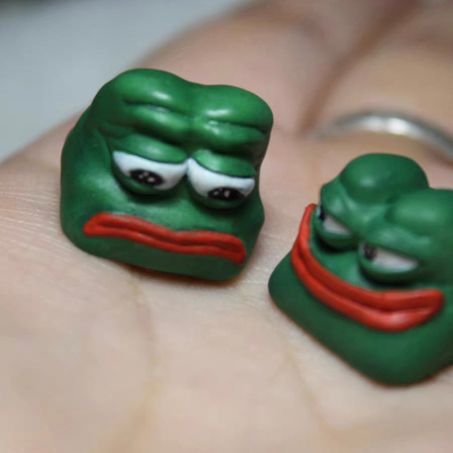 Smiling Frog Keycaps Unique Sad Frog and Funny Frog 3D printed Artisan Keycaps, made to stand out on any keyboard with their playful, green frog designs.