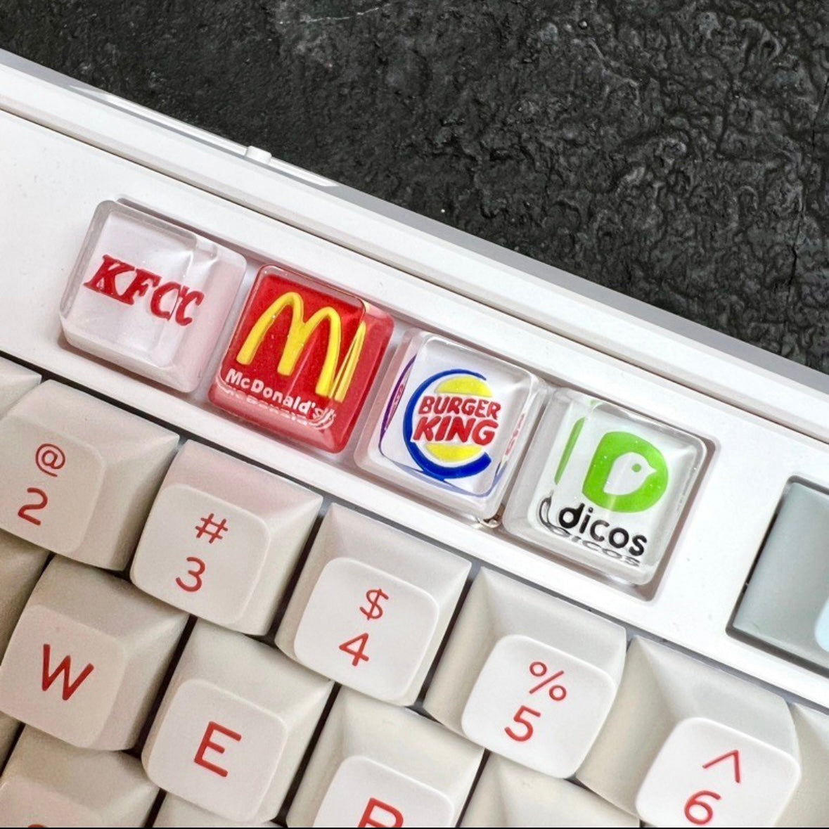 "Show your love for fast food and coffee giants with our custom artisan keycaps featuring iconic logos from Burger King, McDonald's, Starbucks, and KFC. These keycaps are a unique blend of foodie culture and keyboard aesthetics. Crafted with precision, they make a deliciously stylish addition to your setup. Express your passion for your favorite brands with these eye-catching keycaps." 🍔🍟🍗🍕☕💻 #KeyboardAccessories #ArtisanKeycaps #FastFoodLove