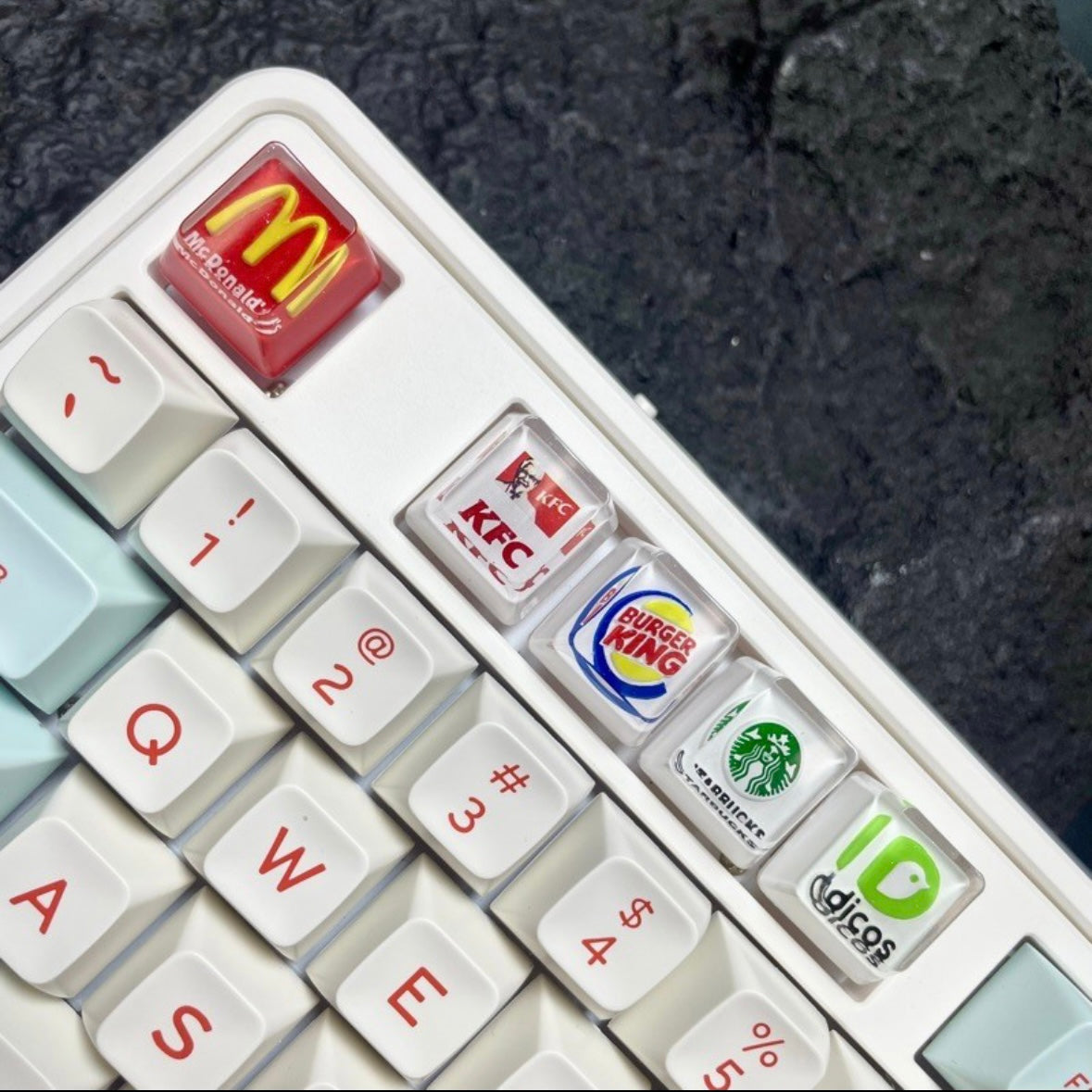 "Show your love for fast food and coffee giants with our custom artisan keycaps featuring iconic logos from Burger King, McDonald's, Starbucks, and KFC. These keycaps are a unique blend of foodie culture and keyboard aesthetics. Crafted with precision, they make a deliciously stylish addition to your setup. Express your passion for your favorite brands with these eye-catching keycaps." 🍔🍟🍗🍕☕💻 #KeyboardAccessories #ArtisanKeycaps #FastFoodLove