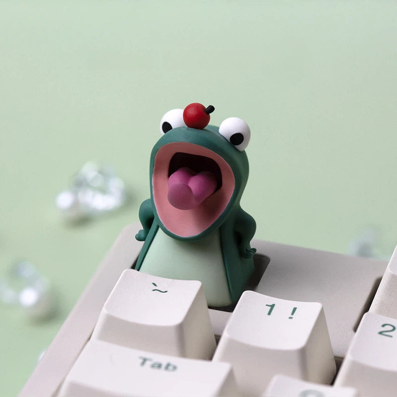 Playful animal inspired resin artisan keycap featuring cute frog characters for custom mechanical keyboards. The handmade epoxy resin design creates a unique collectible accessory for ESC keys, artisan positions, and themed keyboard setups.