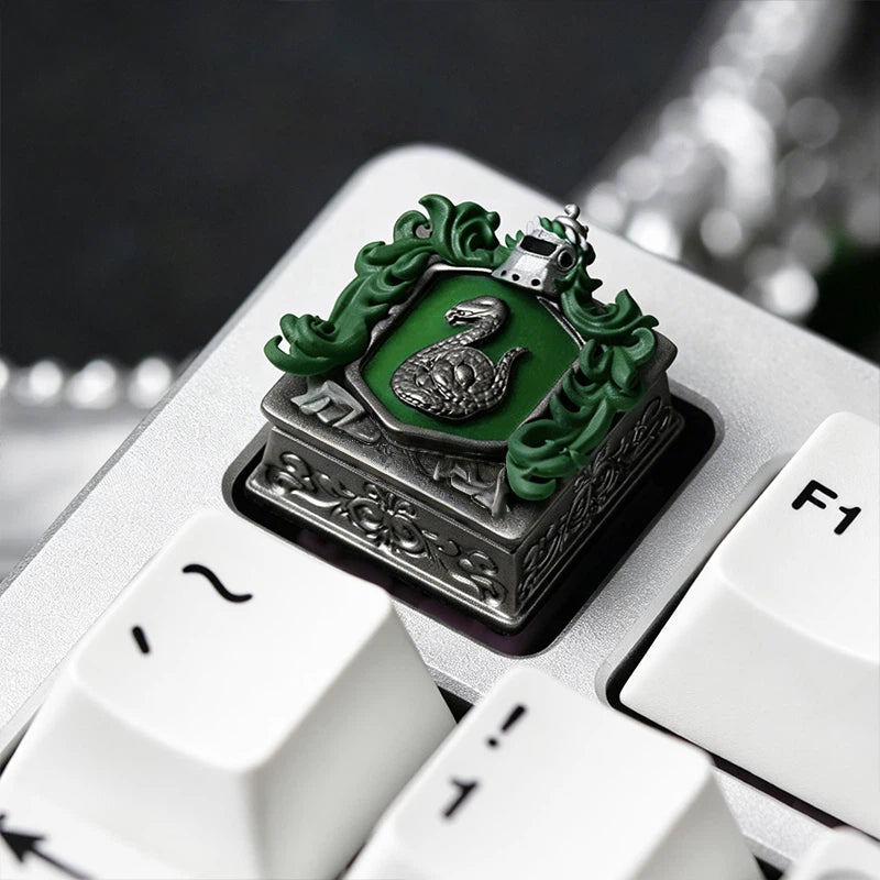 Fantasy resin artisan keycap set featuring the four Hogwarts house crests including Gryffindor, Slytherin, Ravenclaw, and Hufflepuff. Each keycap showcases detailed house symbols and adds a magical touch to mechanical keyboard collections.