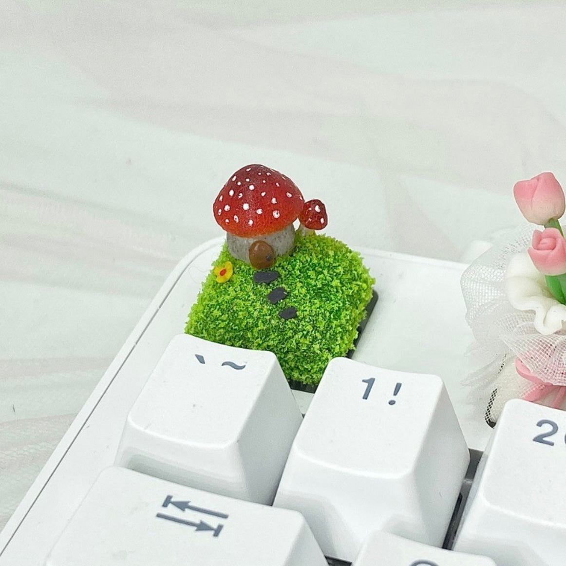 Handcrafted Mushroom Keycap Set  Step into a whimsical world with our Handmade Mushroom Keycap Set, where mushrooms thrive on a bed of lush moss, adding an enchanting touch to your keyboard.  Mystical Details:  Each keycap is a testament to craftsmanship, meticulously created to resemble the beauty of nature. These tiny mushrooms sprout from a bed of moss, making your keyboard a portal to a fairy tale realm.