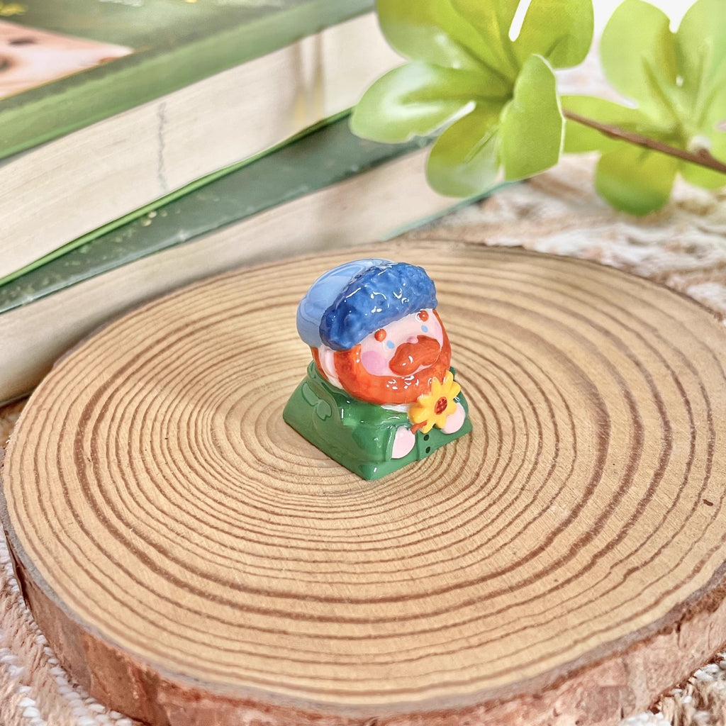 "Indulge in the artistic charm of our Resin Van Gogh Artisan Keycap – a lovable chibi rendition of Van Gogh holding a sunflower. This keycap is not just a functional accessory; it's a true masterpiece. Crafted from high-quality resin and coated with a surface layer, it exudes the delicate elegance of ceramic while being crafted from resin material. Transform your keyboard into a canvas of art with this adorable keycap, where every keystroke becomes a stroke of cuteness and craftsmanship. 