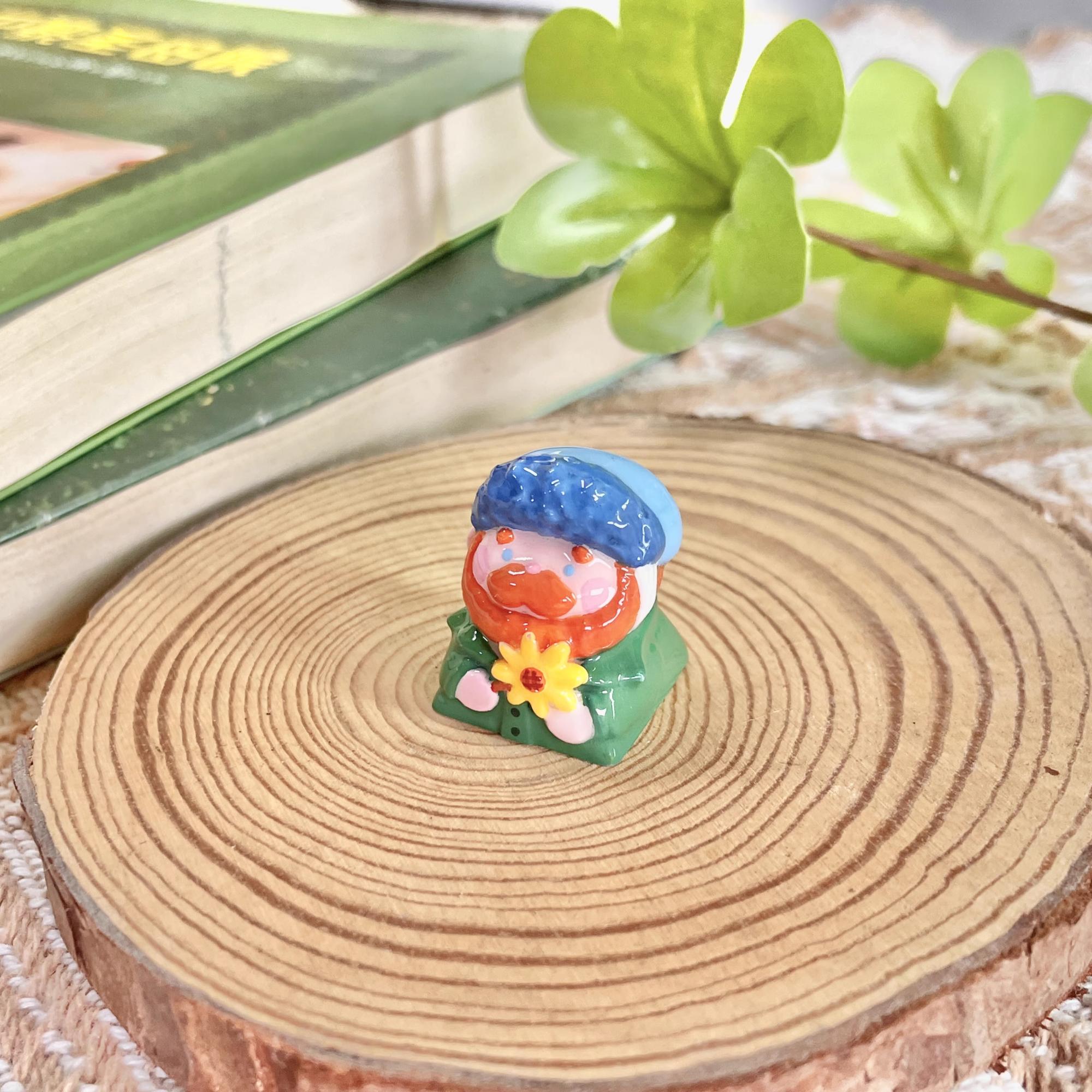 "Indulge in the artistic charm of our Resin Van Gogh Artisan Keycap – a lovable chibi rendition of Van Gogh holding a sunflower. This keycap is not just a functional accessory; it's a true masterpiece. Crafted from high-quality resin and coated with a surface layer, it exudes the delicate elegance of ceramic while being crafted from resin material. Transform your keyboard into a canvas of art with this adorable keycap, where every keystroke becomes a stroke of cuteness and craftsmanship. 