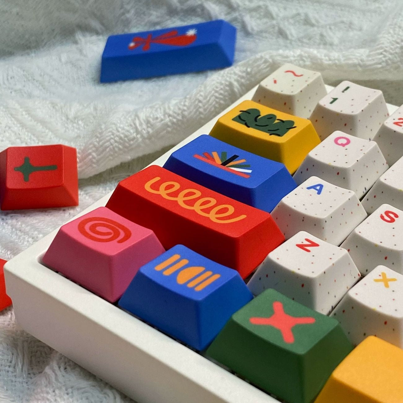 Close-up view of colorful motif keycaps showing geometric patterns, detailed legends, and premium PBT texture