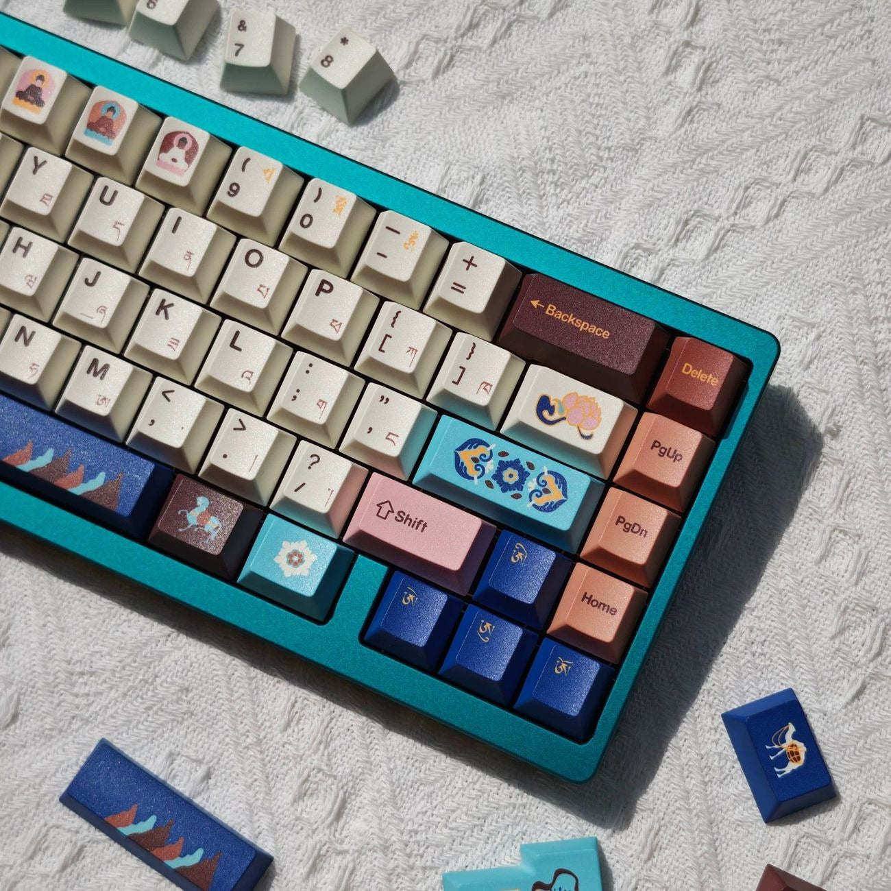 Nine color Tibetan inspired keycap design combining blue, pink, turquoise, and white tones for a unique mechanical keyboard aesthetic