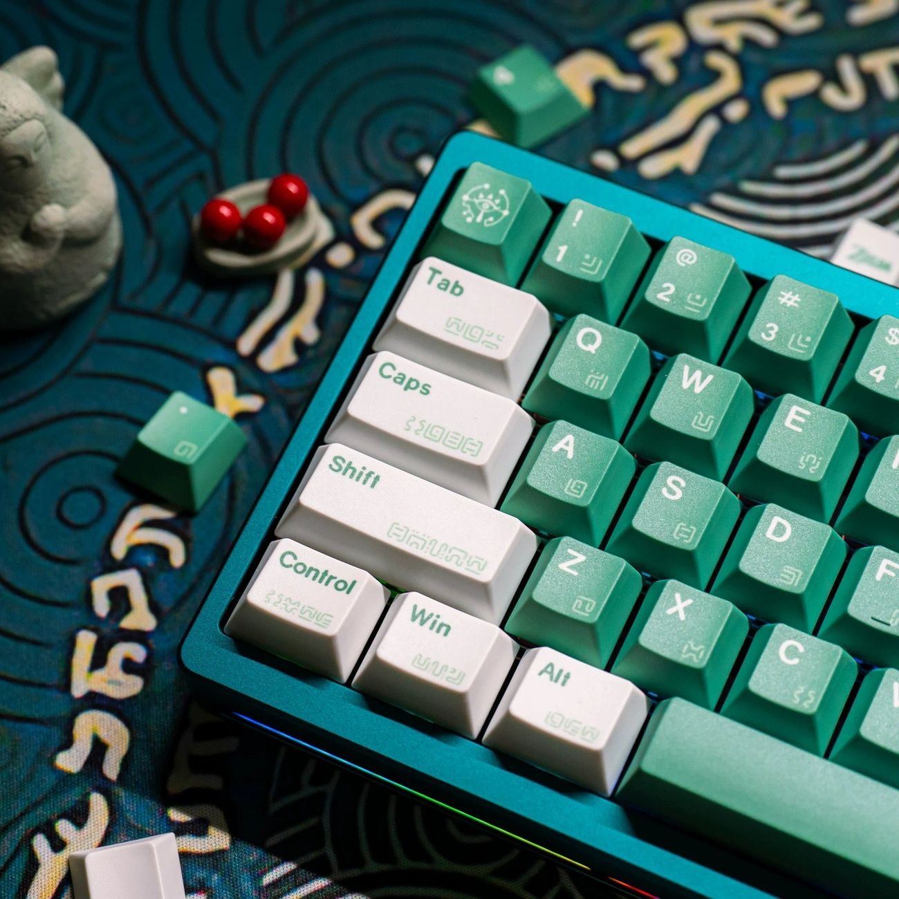 Close-up view of fantasy inspired keycaps showing symbolic patterns, detailed legends, and emerald green decorative artwork